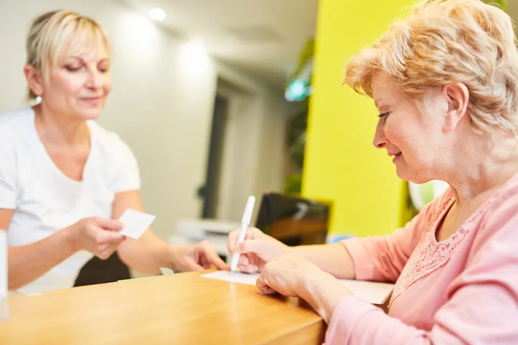 A GP receptionist deals with a patient