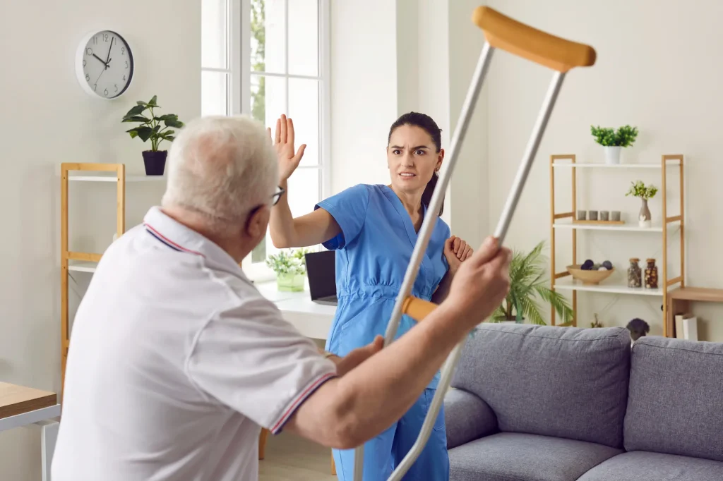 An angry patient threatens a nurse with his walking crutch