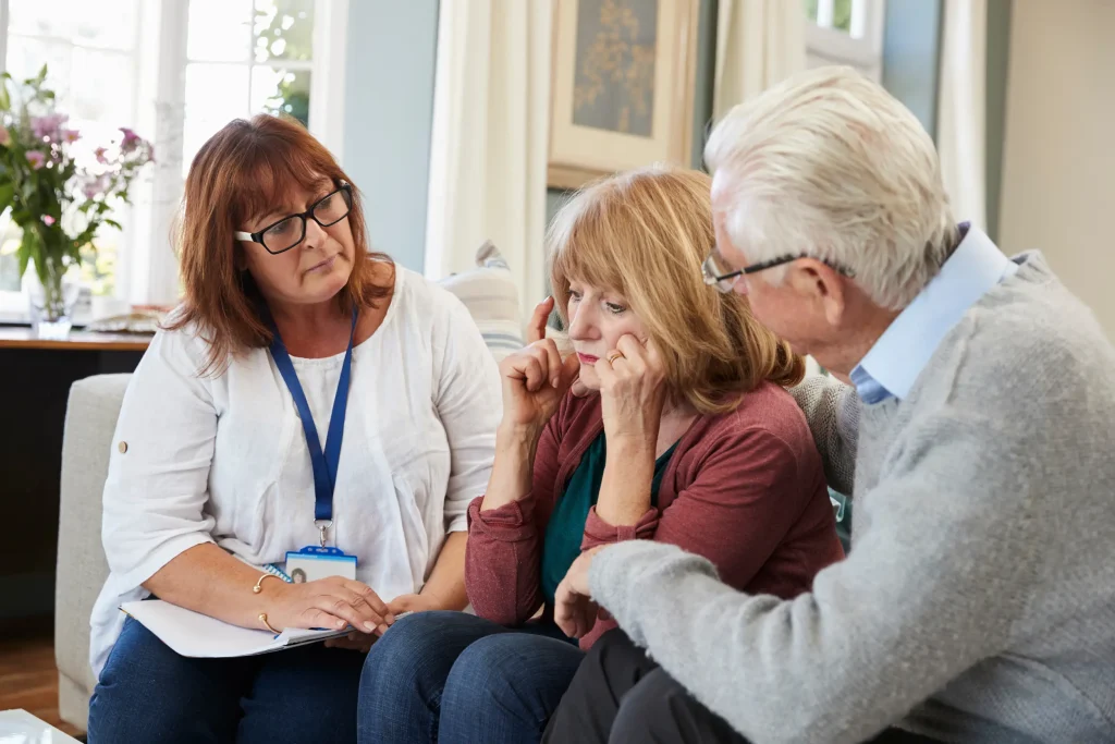 An NHS community nurse comforts an elderly patient in their home