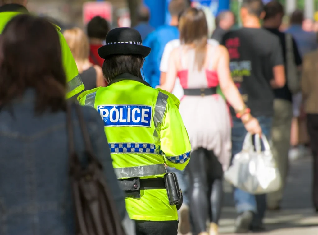 Police officer patrolling a UK high street as part of efforts to tackle retail crime