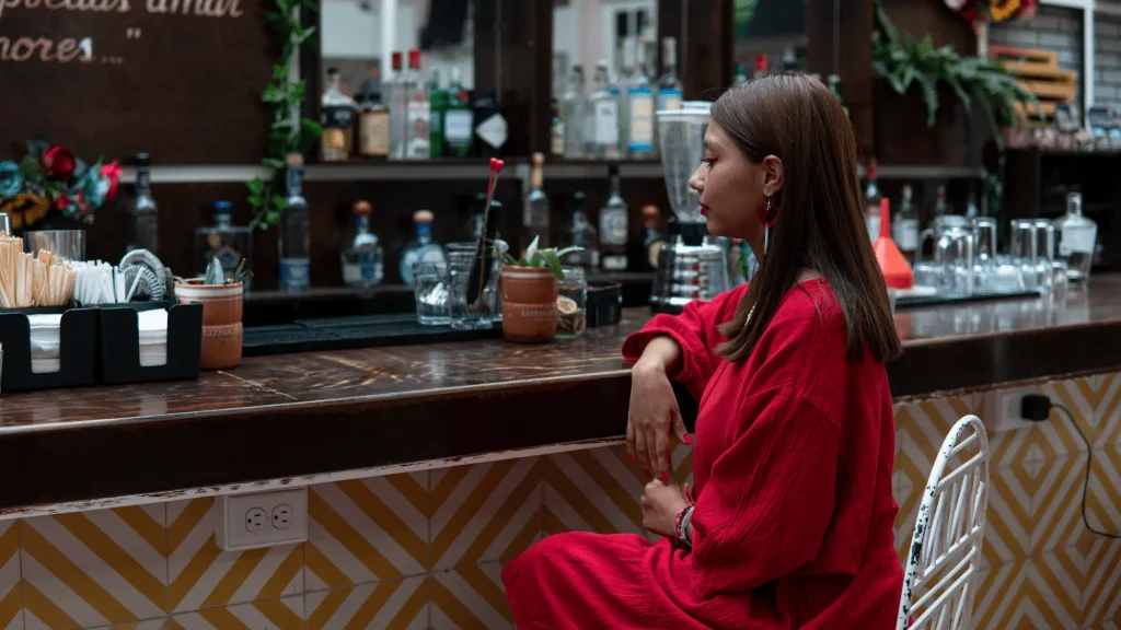 A woman sitting alone at a bar — an everyday scene, and the kind of moment staff safety training is designed to help recognise if circumstances change