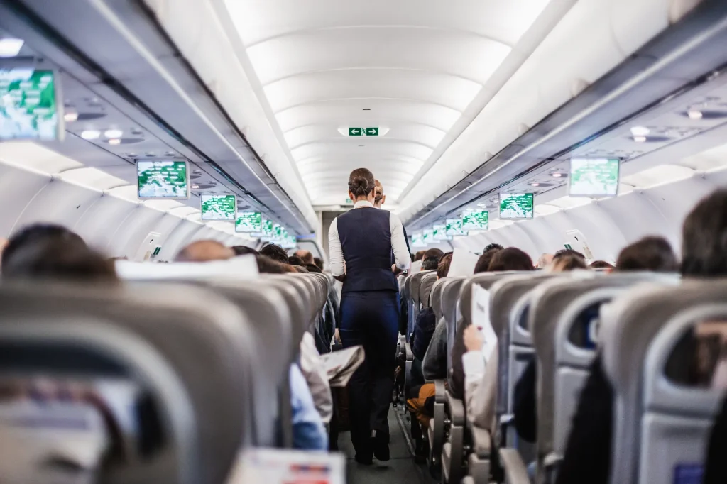 An air stewardess serving food and drinks to passengers on a plane