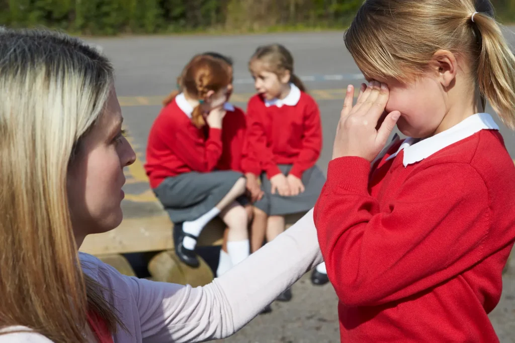 a teacher comforts a young pupil using her positive handling training