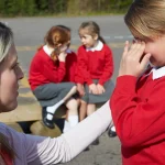 a teacher comforts a young pupil using her positive handling training